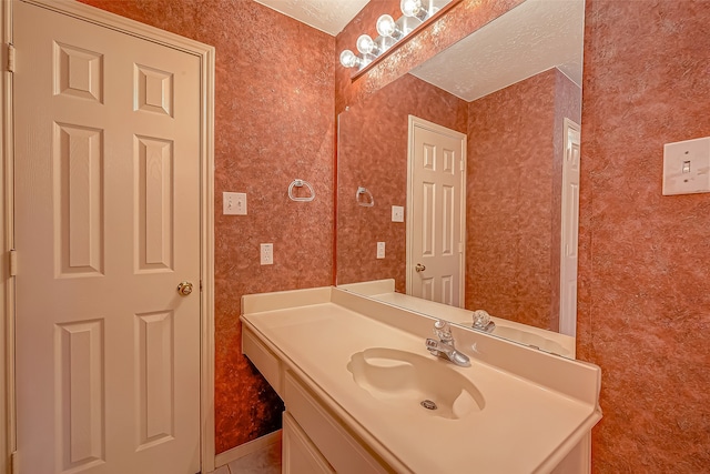 bathroom with a textured ceiling and vanity