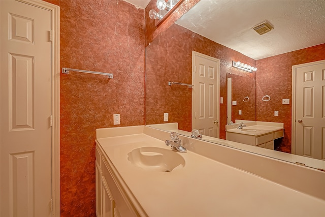 bathroom featuring a textured ceiling and vanity