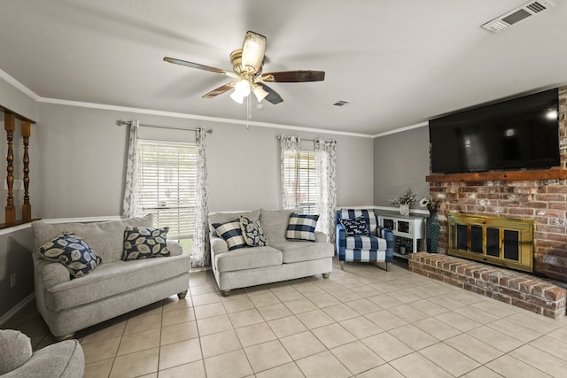 tiled living room featuring ornamental molding, a healthy amount of sunlight, a fireplace, and ceiling fan