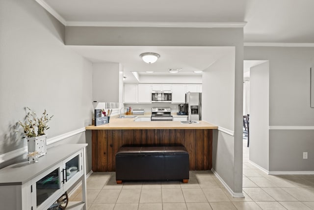 kitchen with kitchen peninsula, stainless steel appliances, crown molding, sink, and white cabinets