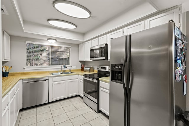 kitchen with white cabinets, stainless steel appliances, sink, and light tile patterned floors