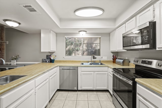 kitchen with light tile patterned flooring, white cabinetry, stainless steel appliances, and sink