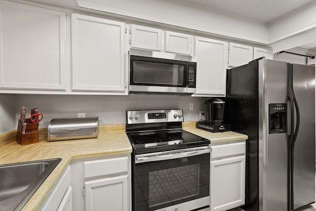 kitchen with appliances with stainless steel finishes and white cabinetry