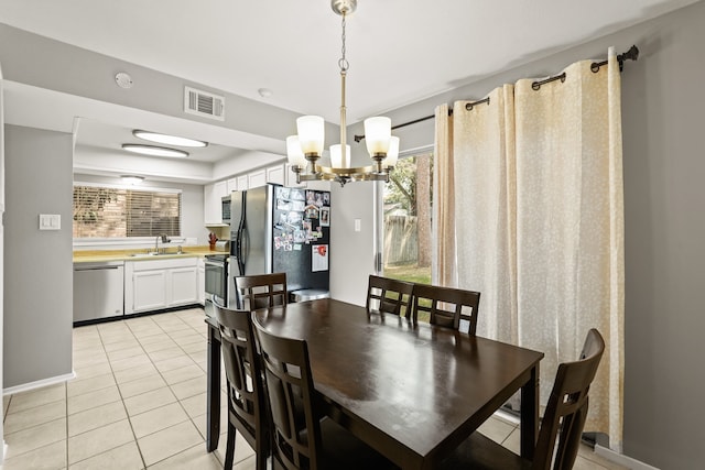 tiled dining area featuring an inviting chandelier and sink