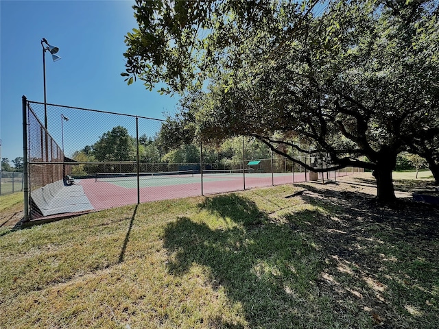 view of sport court with a yard