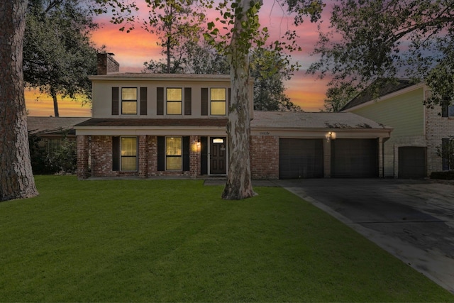 colonial-style house featuring a yard and a garage