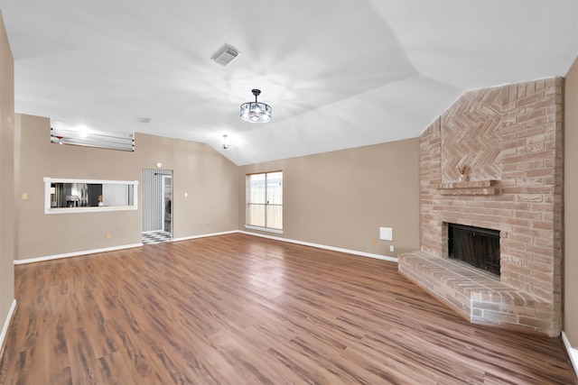 unfurnished living room with lofted ceiling, hardwood / wood-style flooring, and a fireplace