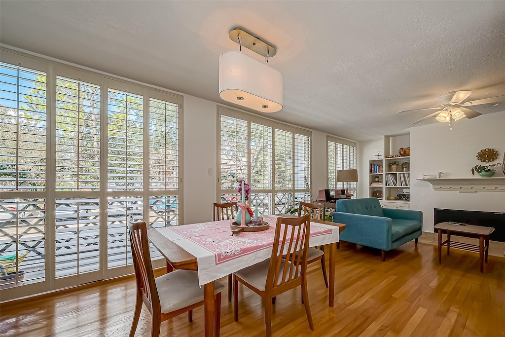 dining space with a wealth of natural light, a textured ceiling, light hardwood / wood-style flooring, and ceiling fan