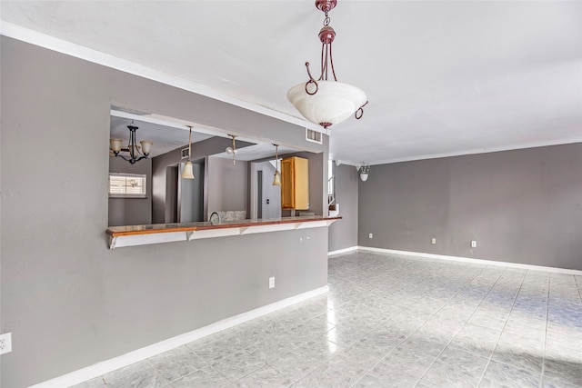 kitchen featuring a chandelier, kitchen peninsula, a kitchen bar, decorative light fixtures, and ornamental molding