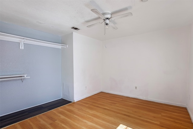 spare room featuring ceiling fan, hardwood / wood-style flooring, and a textured ceiling