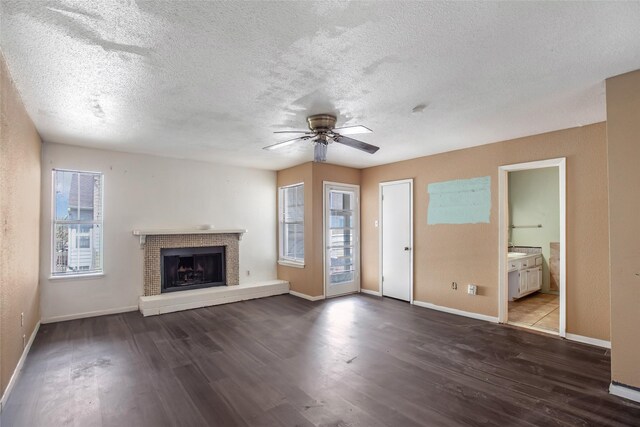 unfurnished living room featuring a wealth of natural light, a textured ceiling, and dark hardwood / wood-style floors