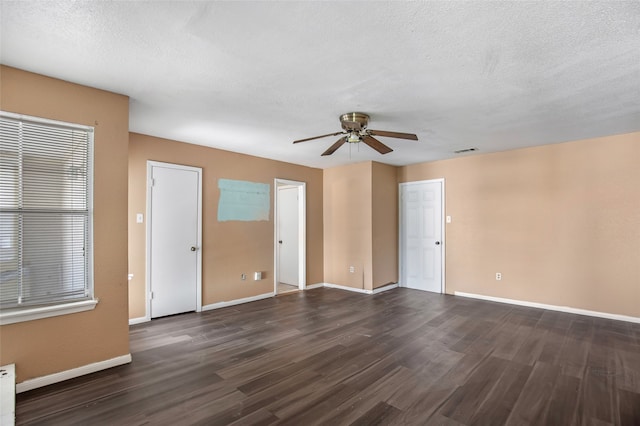 spare room with ceiling fan, dark hardwood / wood-style floors, and a textured ceiling