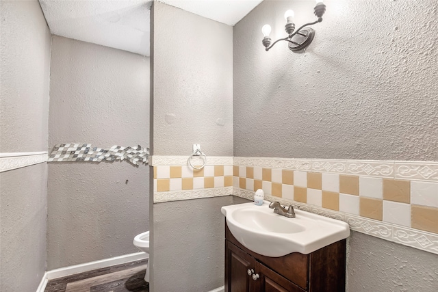 bathroom with hardwood / wood-style floors, vanity, and toilet