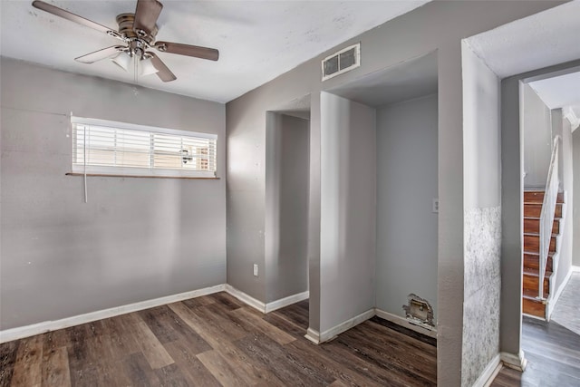 unfurnished room with ceiling fan and dark wood-type flooring