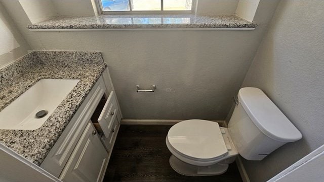 bathroom with hardwood / wood-style flooring, vanity, and toilet