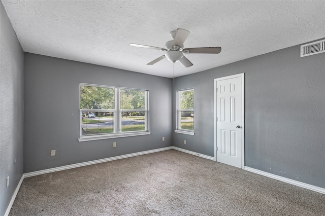 carpeted spare room featuring a textured ceiling and ceiling fan