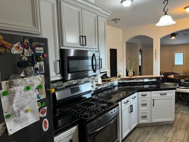 kitchen with ceiling fan, white cabinets, hanging light fixtures, tasteful backsplash, and stainless steel appliances