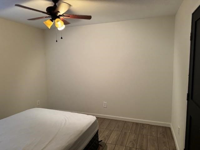 unfurnished bedroom with ceiling fan and hardwood / wood-style flooring