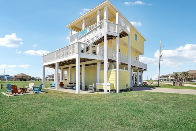 back of property featuring a patio area, a wooden deck, and a lawn