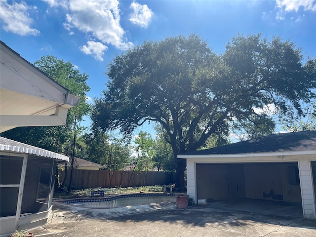 view of side of property with a garage and a fenced in pool