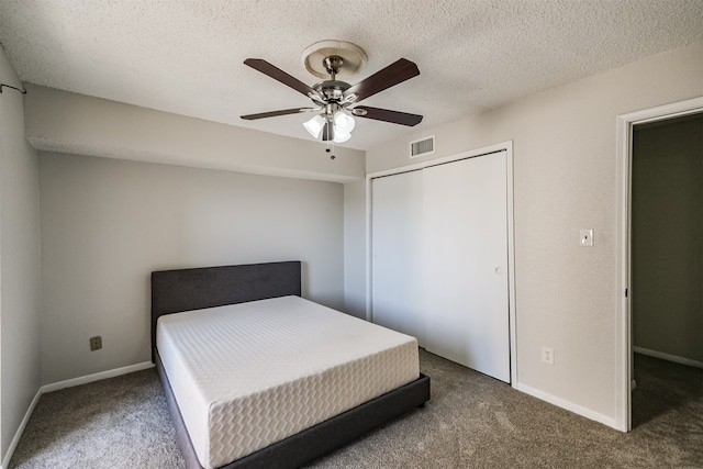 unfurnished bedroom with ceiling fan, a textured ceiling, a closet, and carpet flooring