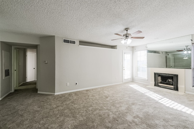 unfurnished living room featuring a textured ceiling, carpet flooring, and ceiling fan