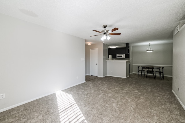 unfurnished living room featuring a textured ceiling, carpet floors, and ceiling fan