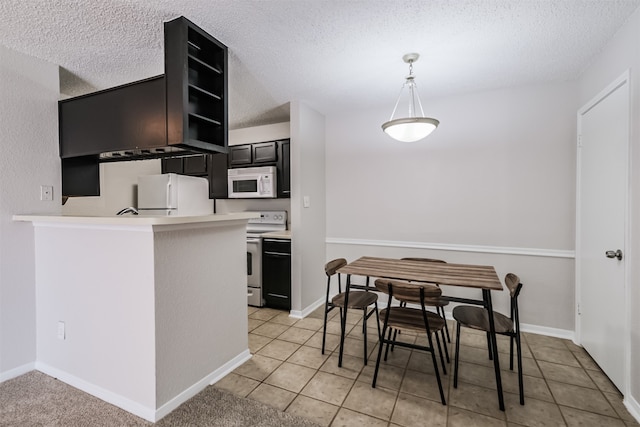 kitchen featuring a textured ceiling, hanging light fixtures, white appliances, and kitchen peninsula