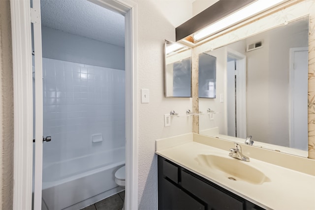 full bathroom featuring tile patterned flooring, a textured ceiling, washtub / shower combination, vanity, and toilet