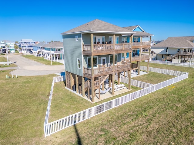 back of house with a balcony and a lawn