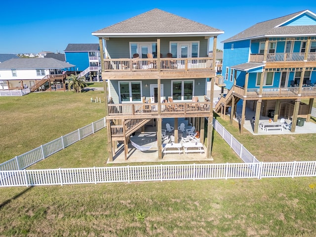 back of house with a balcony, a patio, and a lawn