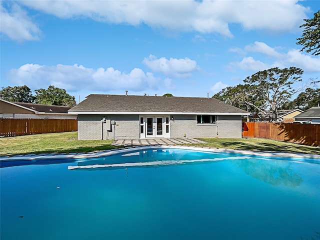 view of pool with a lawn and french doors