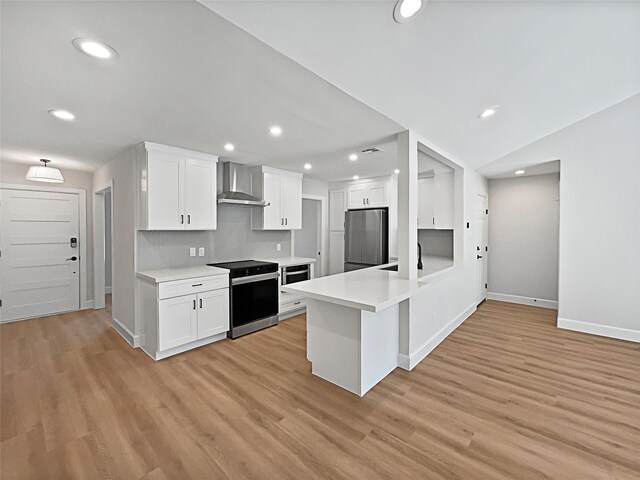 5743 Ludington Dr, Houston, TX 77035 - kitchen with wall chimney exhaust hood, freestanding refrigerator, light wood finished floors, and electric range