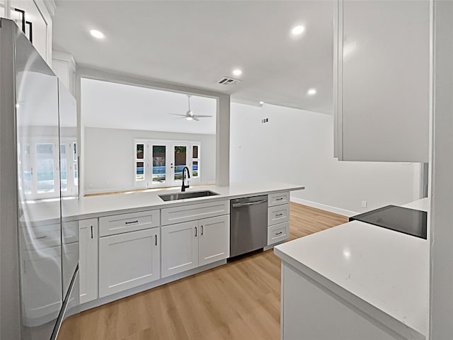 kitchen with white cabinets, dishwasher, light hardwood / wood-style floors, and sink