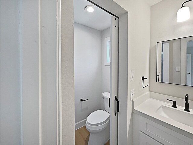 5743 Ludington Dr, Houston, TX 77035 - bathroom featuring wood finished floors, toilet, and vanity