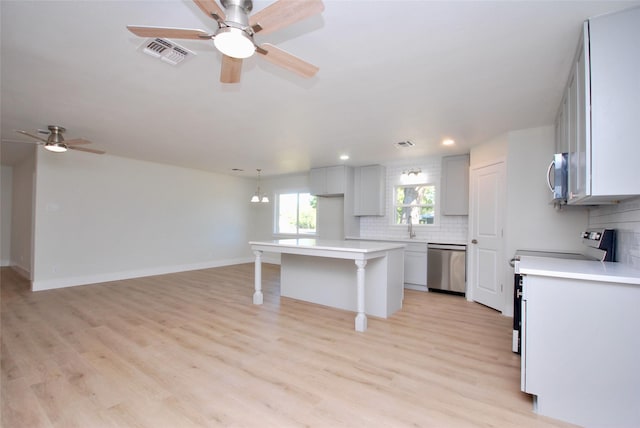 316 N Penn, Flatonia, TX 78941 - kitchen featuring stainless steel appliances, visible vents, a kitchen bar, decorative backsplash, and a ceiling fan
