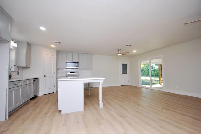 316 N Penn, Flatonia, TX 78941 - kitchen with decorative backsplash, ceiling fan, light wood-style flooring, appliances with stainless steel finishes, and gray cabinetry