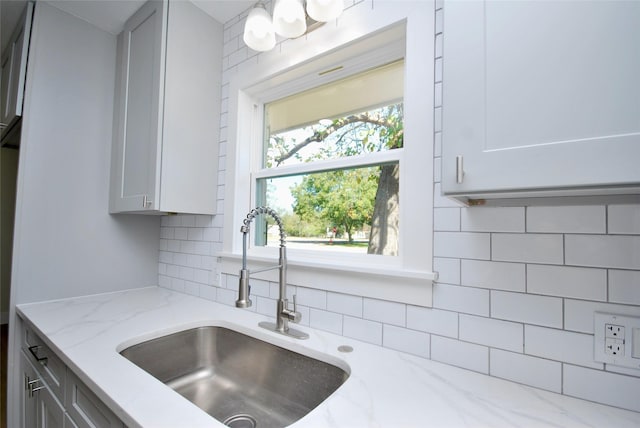 316 N Penn, Flatonia, TX 78941 - kitchen with light stone countertops, gray cabinets, decorative backsplash, and a sink
