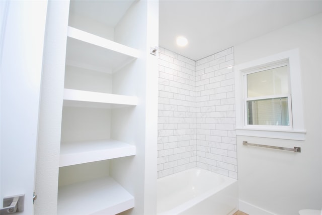 bathroom with tiled shower / bath and toilet