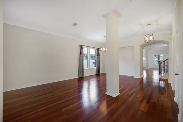 unfurnished room featuring decorative columns, crown molding, and dark hardwood / wood-style flooring