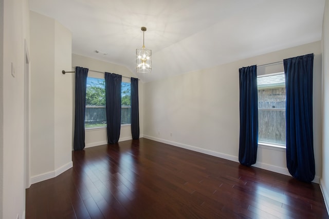 unfurnished room featuring a notable chandelier, dark hardwood / wood-style floors, and a wealth of natural light