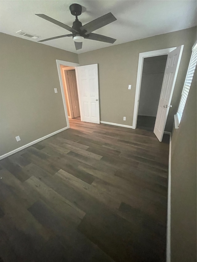 unfurnished bedroom with ceiling fan and dark wood-type flooring