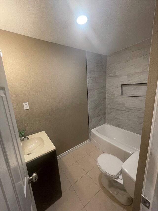 full bathroom featuring tiled shower / bath, vanity, a textured ceiling, tile patterned floors, and toilet