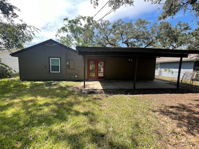 rear view of house with french doors and a lawn