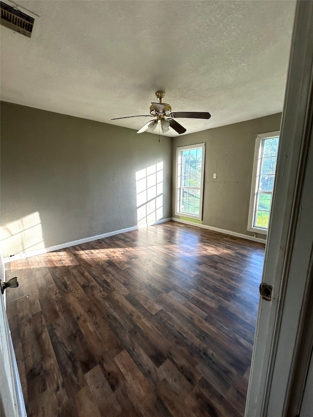 spare room with ceiling fan, a textured ceiling, and dark hardwood / wood-style floors