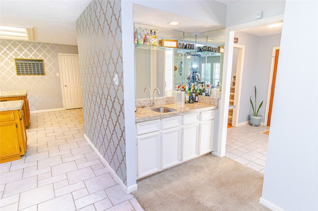 bathroom with tile patterned floors, a textured ceiling, and vanity