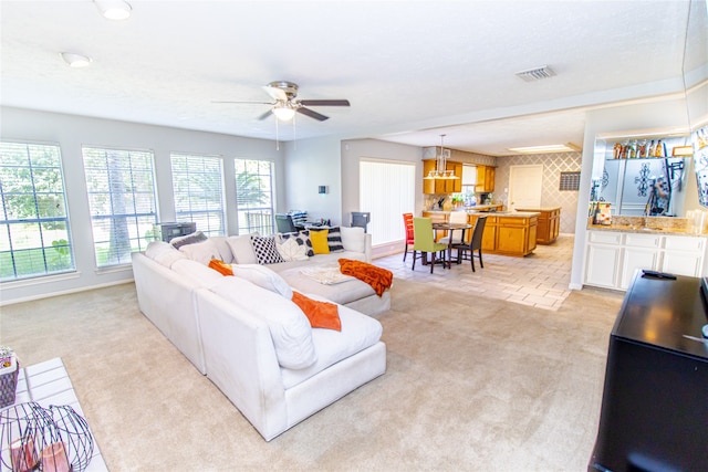 carpeted living room featuring ceiling fan and a textured ceiling