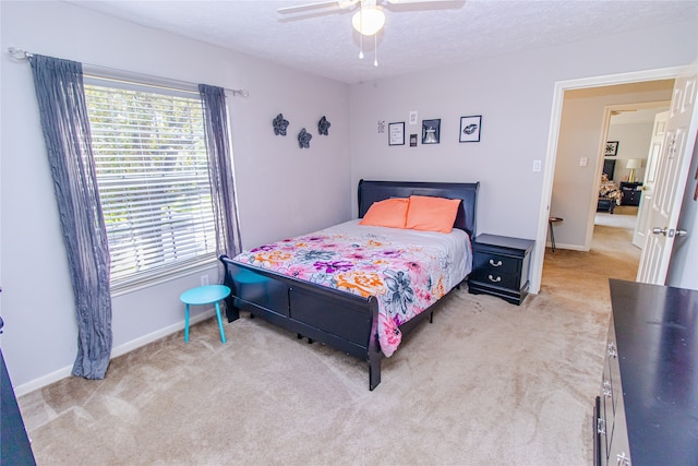 carpeted bedroom featuring ceiling fan and a textured ceiling