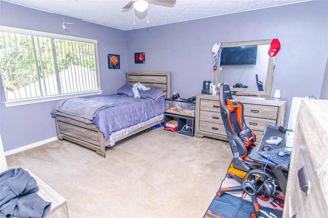 carpeted bedroom with ceiling fan and a textured ceiling