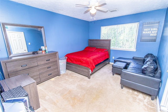 carpeted bedroom featuring ceiling fan and a textured ceiling